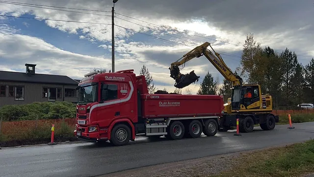 Anleggsmaskin legger jord i en lastebil